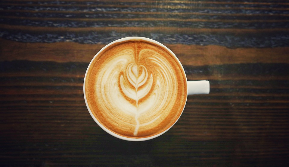 Coffee with a cream swirl design on a wooden background